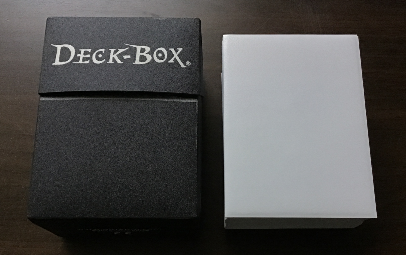 Black deck box with white sleeved cards next to it